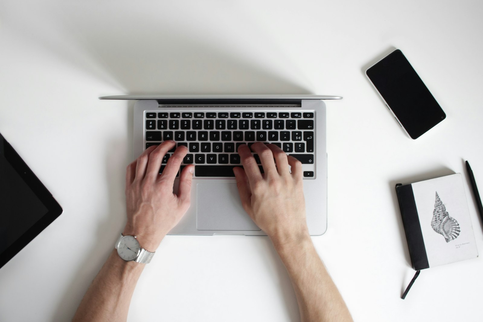 Hands typing on a laptop keyboard