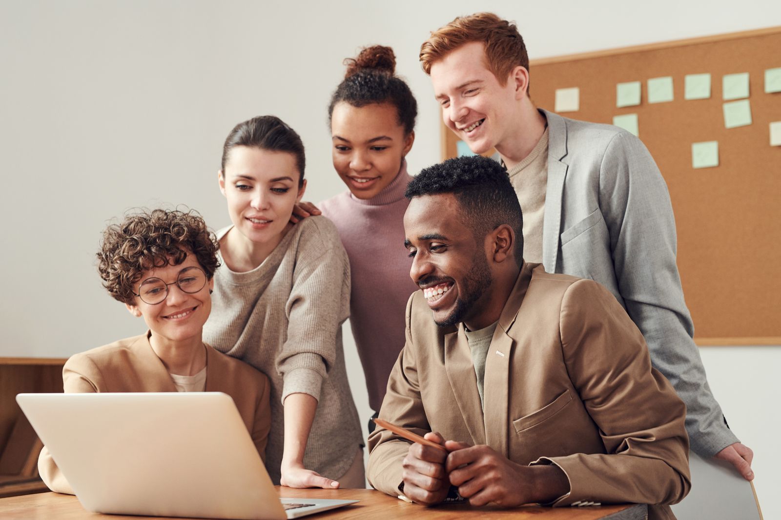 Smiling team looking at a laptop together