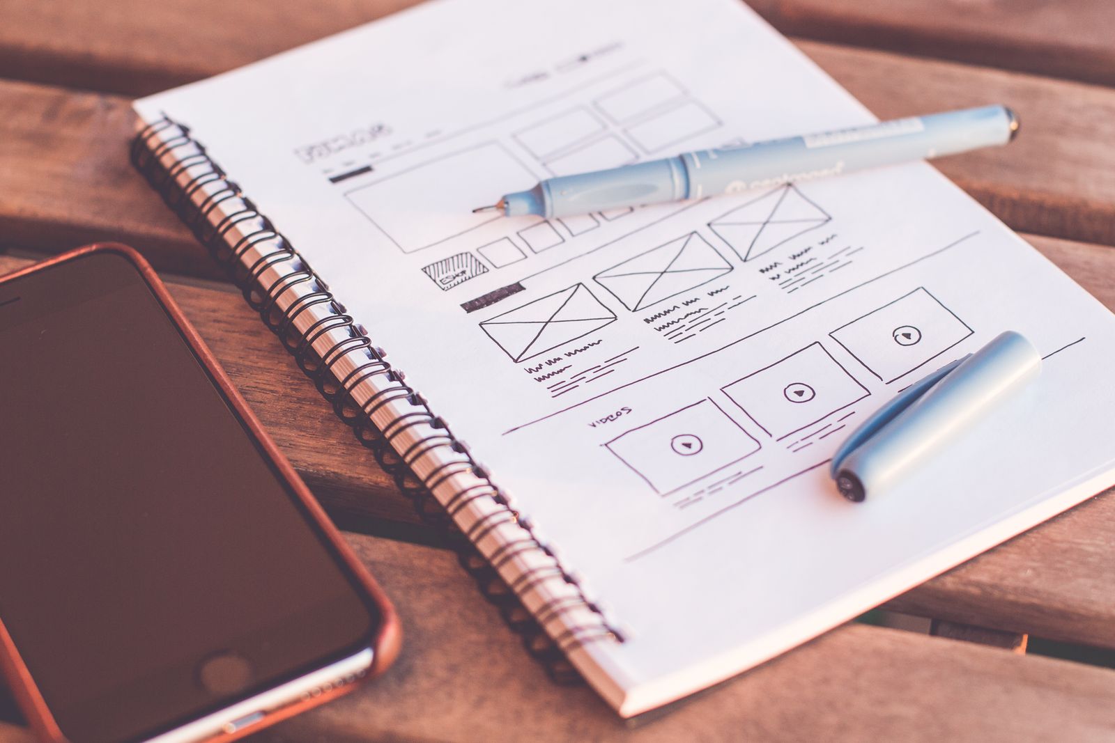 Website wireframe sketches and notes on a desk